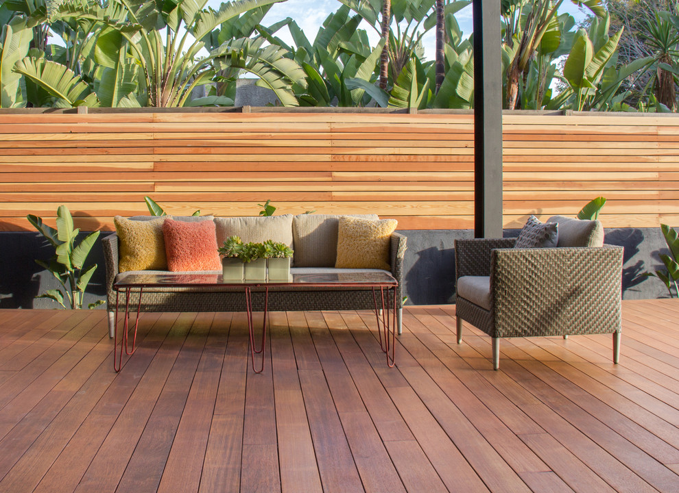 Photo of a contemporary backyard deck in Los Angeles with a roof extension.