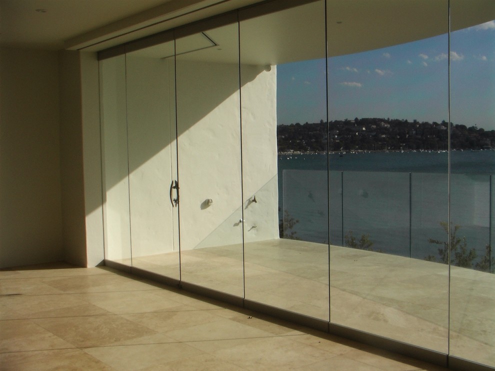 Inspiration for an expansive contemporary enclosed living room in Sydney with white walls and travertine floors.