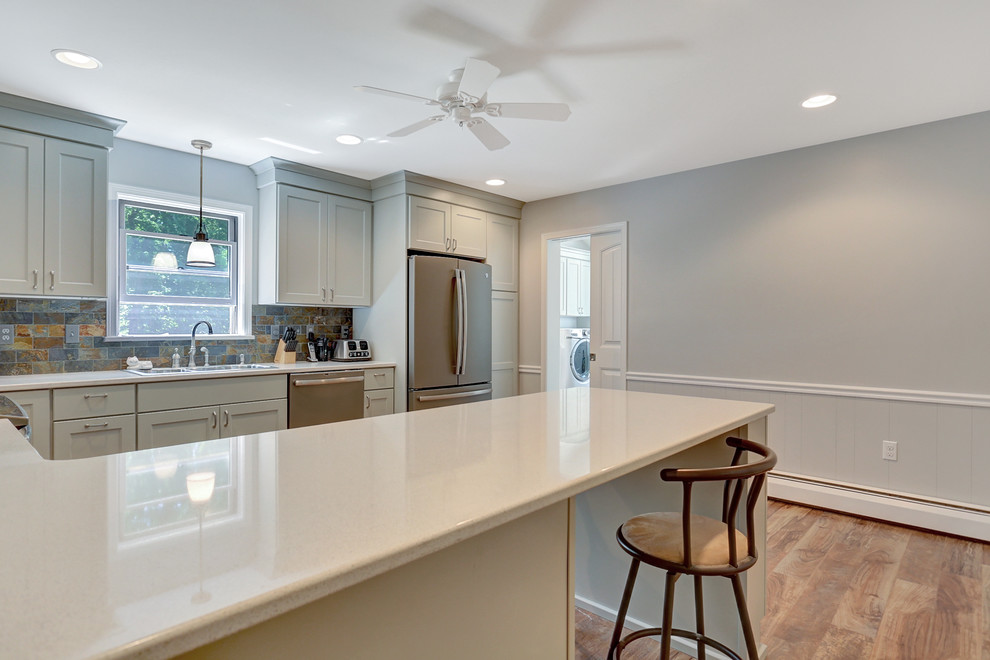 Inspiration for a large eclectic u-shaped medium tone wood floor enclosed kitchen remodel with shaker cabinets, beige cabinets, quartz countertops, multicolored backsplash, stone tile backsplash, stainless steel appliances and no island