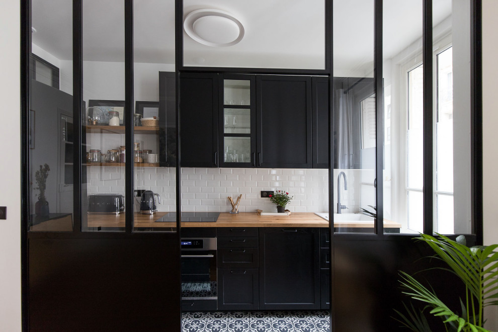 Small contemporary single-wall kitchen in Paris with black cabinets, laminate benchtops, white splashback, ceramic splashback, no island and beige benchtop.