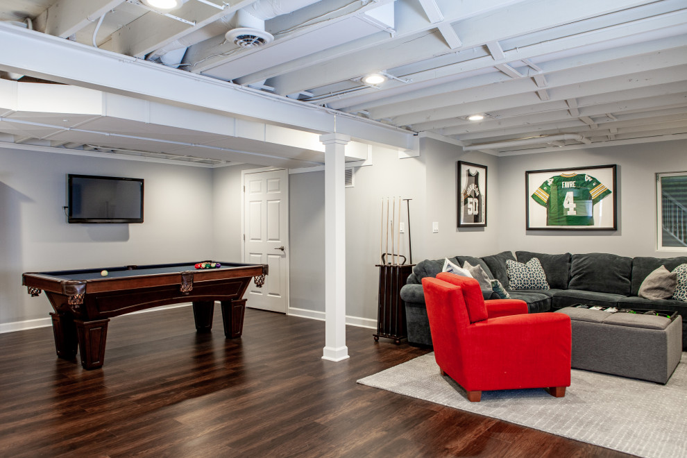 Design ideas for a large transitional fully buried basement in Chicago with a game room, grey walls, vinyl floors, brown floor and exposed beam.