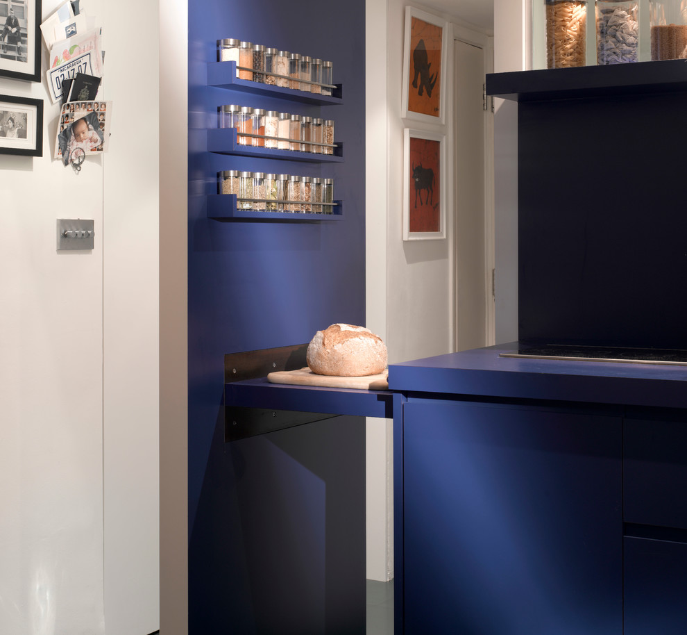 Inspiration for a small contemporary open plan kitchen in London with a drop-in sink, flat-panel cabinets, blue cabinets, stainless steel appliances and ceramic floors.