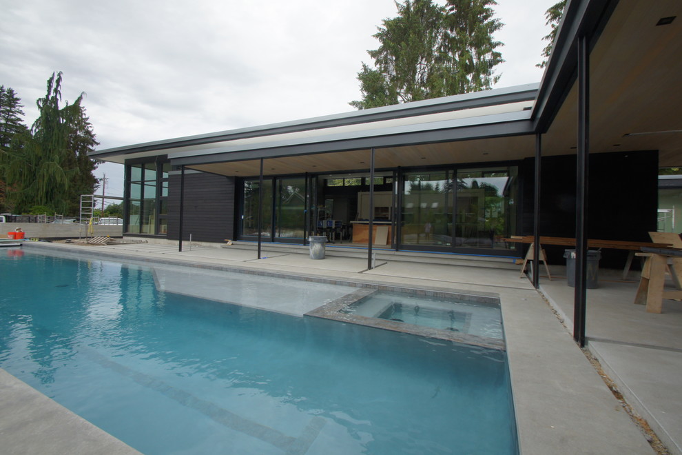 Photo of a modern one-storey black exterior in Seattle with wood siding and a flat roof.