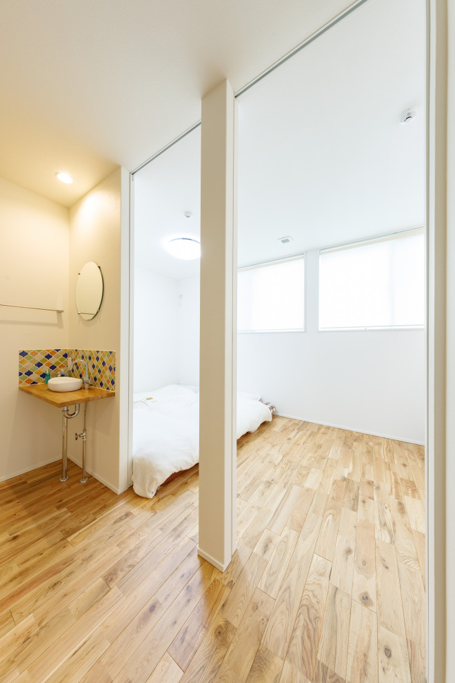 Photo of a small scandinavian master bedroom in Tokyo Suburbs with brown walls, medium hardwood floors, brown floor, wallpaper and wallpaper.