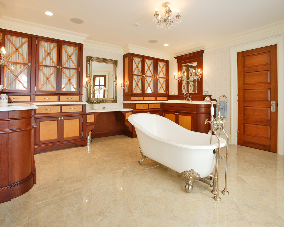 This is an example of a traditional bathroom in New York with medium wood cabinets, a claw-foot tub, beige tile and beaded inset cabinets.