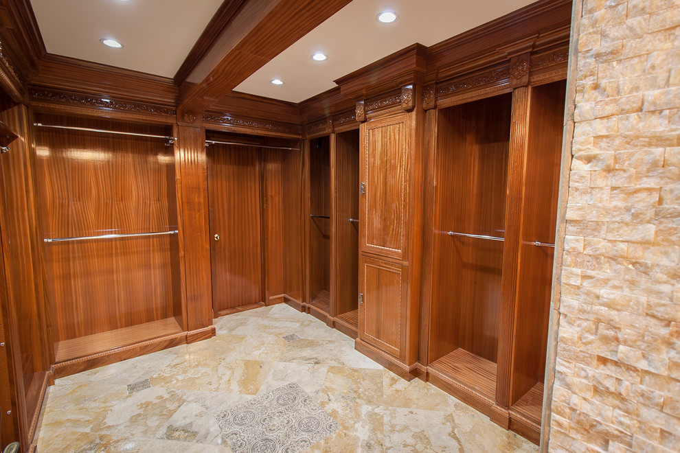 Inspiration for a traditional gender-neutral walk-in wardrobe in San Diego with medium wood cabinets and travertine floors.