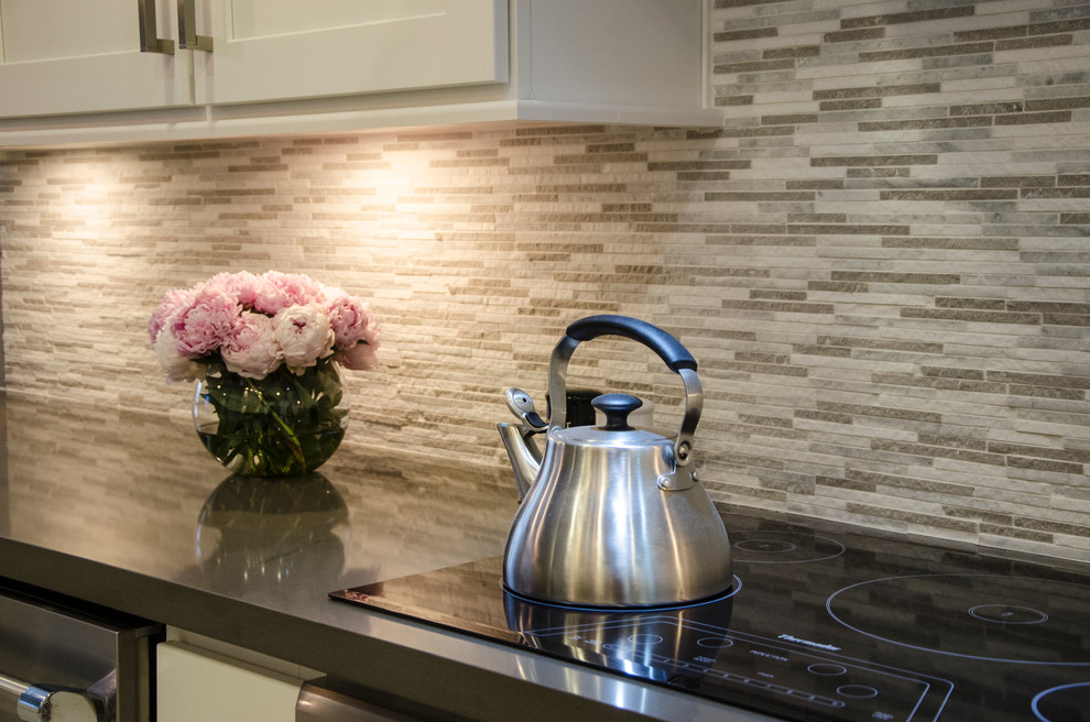 Example of a small transitional u-shaped porcelain tile kitchen design in Miami with a farmhouse sink, shaker cabinets, white cabinets, quartz countertops, gray backsplash, stone tile backsplash, stainless steel appliances and no island