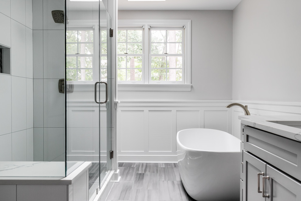 Design ideas for a large traditional master bathroom in Richmond with recessed-panel cabinets, grey cabinets, a freestanding tub, a double shower, a two-piece toilet, white tile, ceramic tile, grey walls, porcelain floors, an undermount sink, quartzite benchtops, grey floor, a hinged shower door and white benchtops.