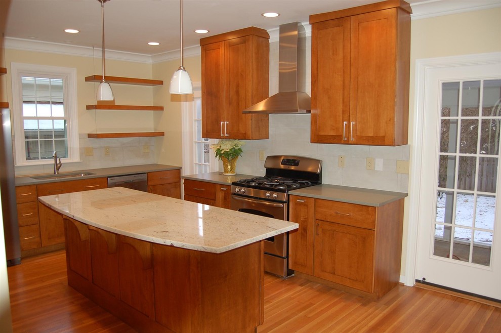 This is an example of a mid-sized contemporary u-shaped open plan kitchen in Indianapolis with an undermount sink, flat-panel cabinets, medium wood cabinets, stainless steel appliances, medium hardwood floors, with island and brown floor.
