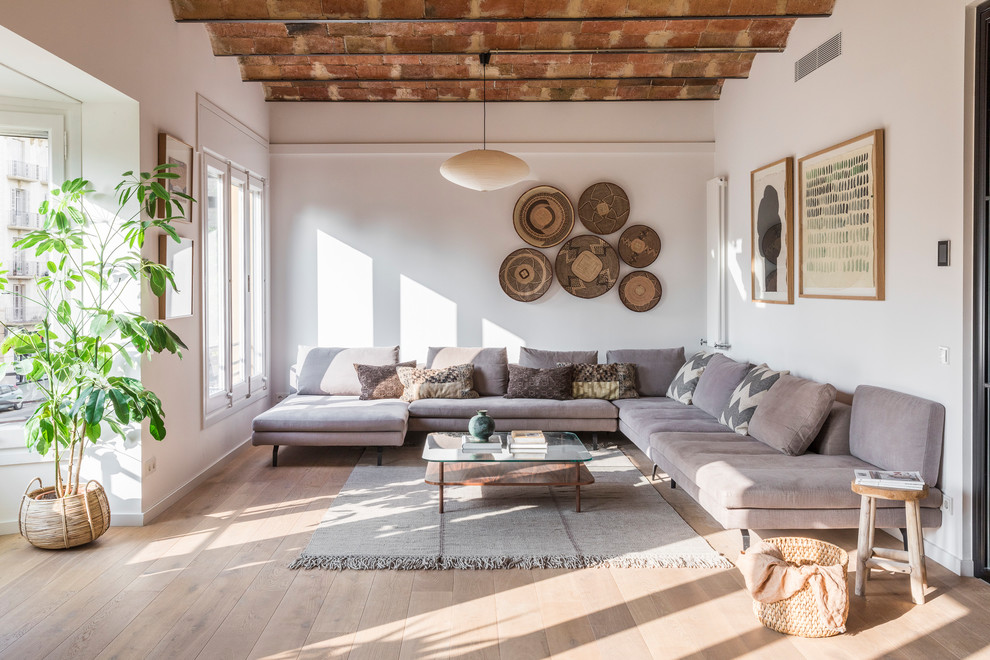 This is an example of a mediterranean formal open concept living room in Barcelona with light hardwood floors, no fireplace, no tv and beige floor.