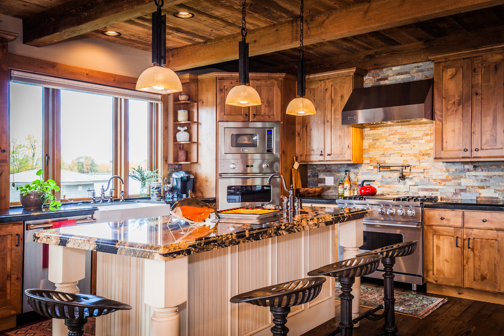 Inspiration for a mid-sized rustic l-shaped dark wood floor open concept kitchen remodel with a farmhouse sink, shaker cabinets, medium tone wood cabinets, granite countertops, multicolored backsplash, stone tile backsplash, stainless steel appliances and an island