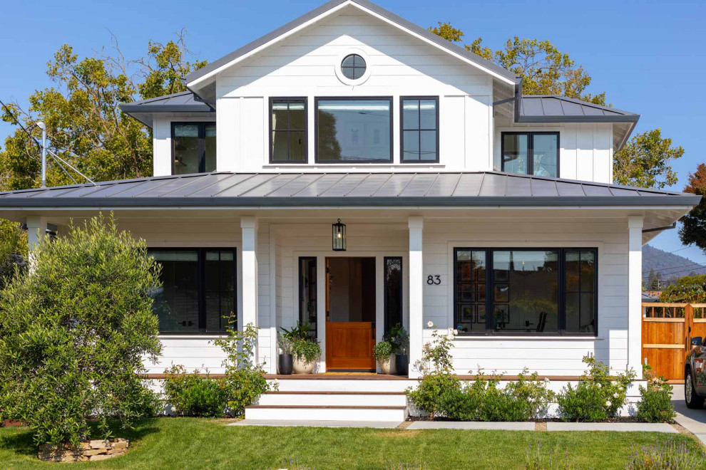 This is an example of a medium sized and white rural two floor detached house in San Francisco with wood cladding, a hip roof, a metal roof, a grey roof and board and batten cladding.