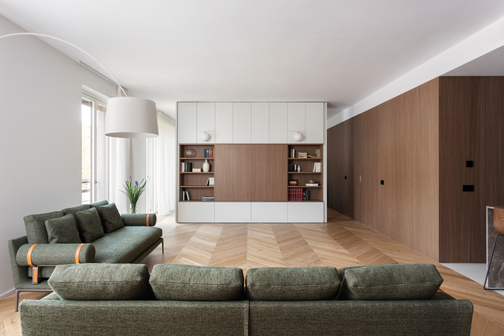 Design ideas for a large modern open concept living room in Milan with white walls, medium hardwood floors and panelled walls.