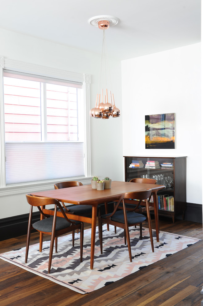 This is an example of an eclectic dining room in Vancouver with white walls, dark hardwood floors and brown floor.