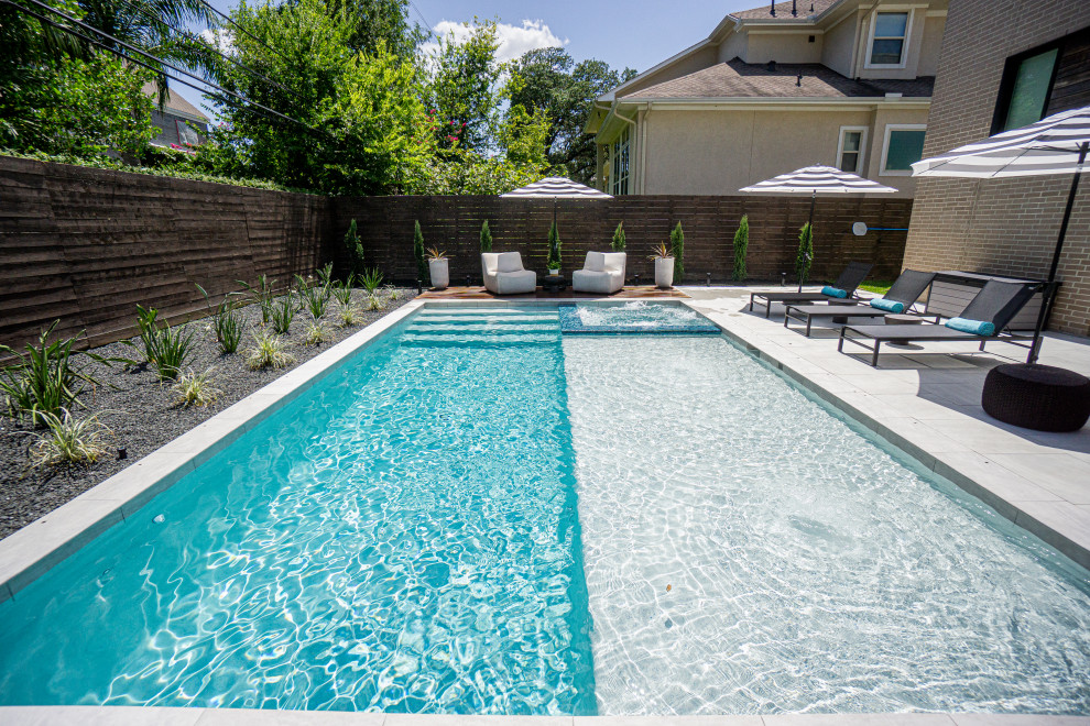 Photo of a large contemporary backyard rectangular pool in Houston with natural stone pavers.