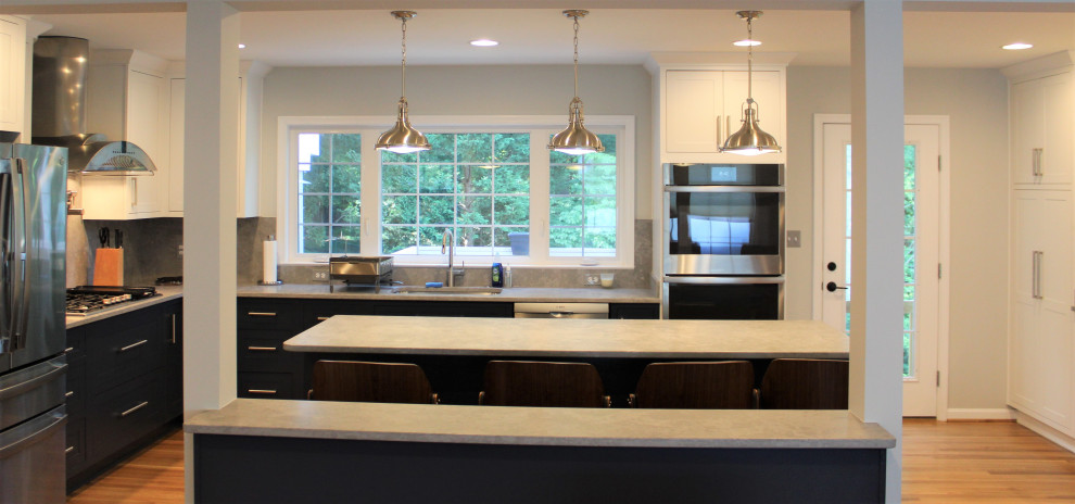 Large transitional u-shaped light wood floor kitchen pantry photo in DC Metro with recessed-panel cabinets, blue cabinets, granite countertops, gray backsplash, ceramic backsplash, stainless steel appliances and an island