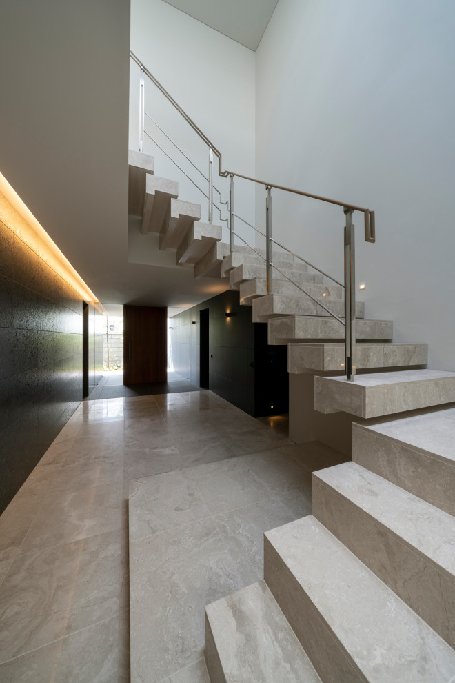 Inspiration för en mycket stor funkis svängd trappa i marmor, med sättsteg i marmor och räcke i metall