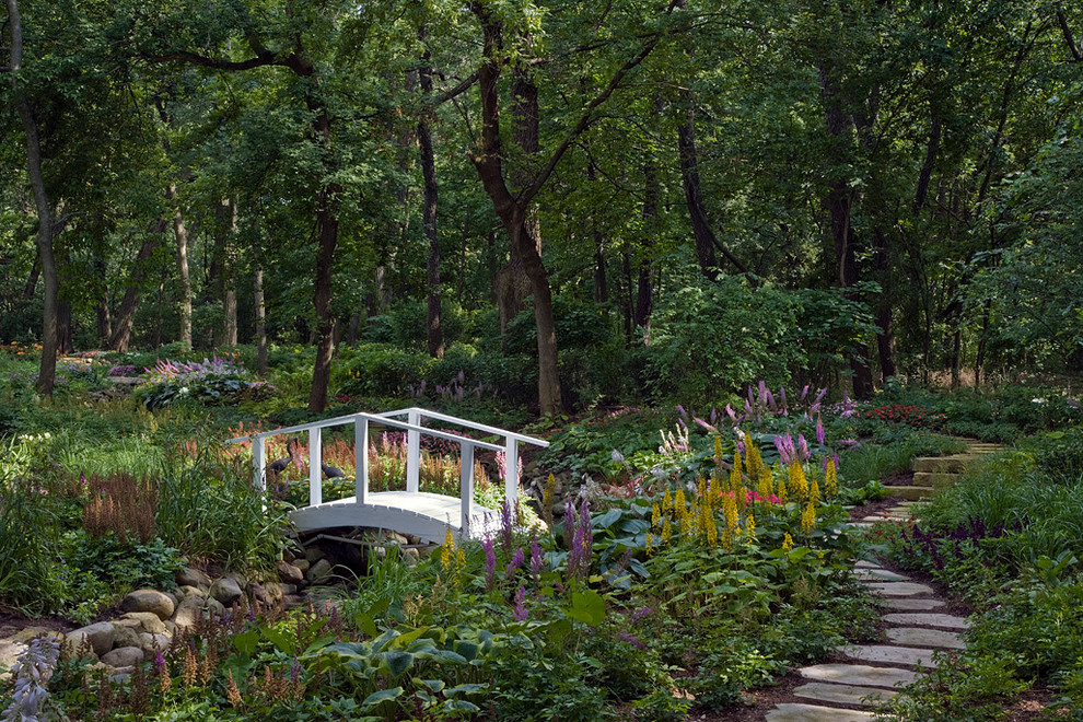Photo of a traditional shaded garden in Chicago with a water feature and natural stone pavers.