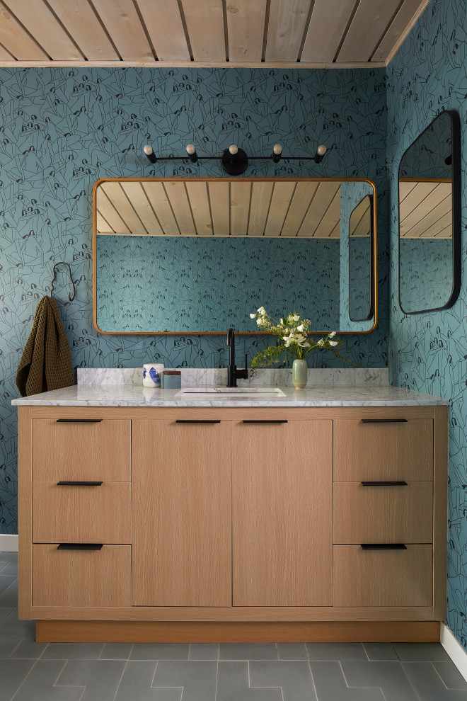 Inspiration for a medium sized midcentury ensuite bathroom in San Francisco with flat-panel cabinets, light wood cabinets, a one-piece toilet, blue walls, cement flooring, a submerged sink, marble worktops, green floors, grey worktops, a single sink, a freestanding vanity unit, a wood ceiling and wallpapered walls.