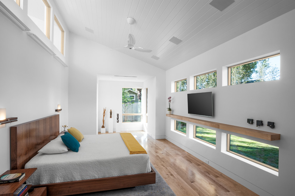 Midcentury master bedroom in Houston with white walls, medium hardwood floors and beige floor.