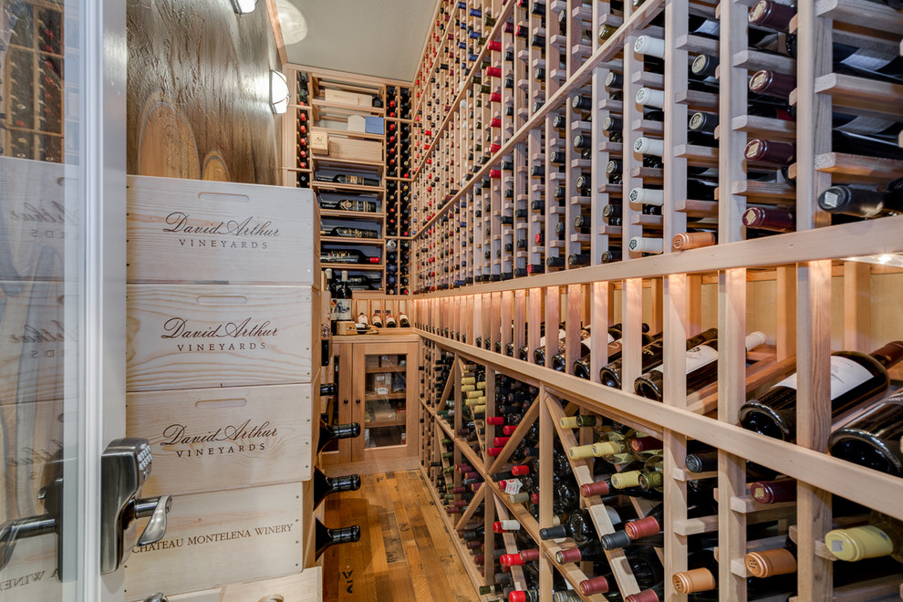 Photo of a traditional wine cellar in Dallas with medium hardwood floors and storage racks.