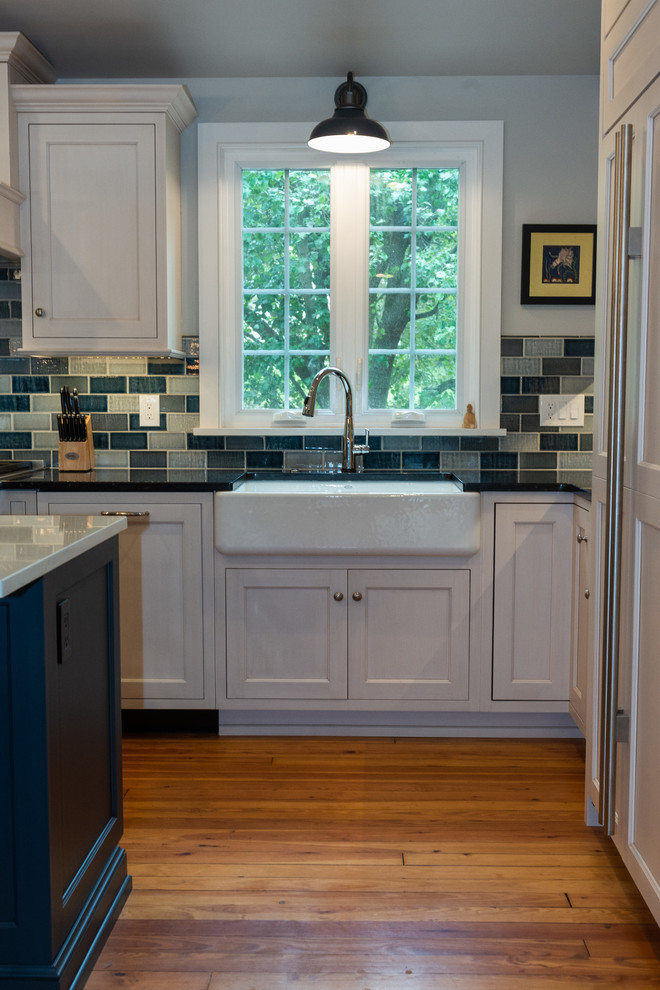 Inspiration for a large transitional open plan kitchen in Philadelphia with a farmhouse sink, white cabinets, blue splashback, panelled appliances and with island.