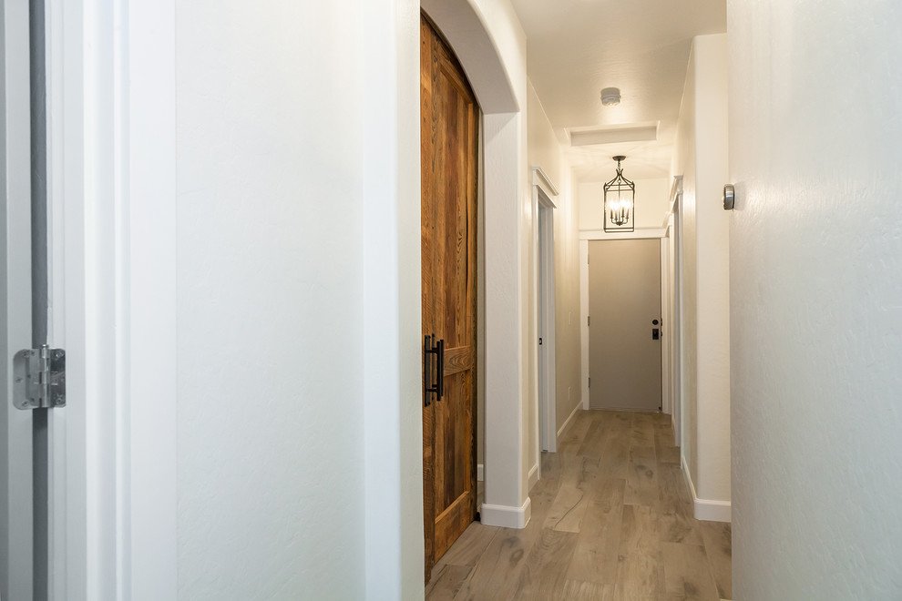 Hallway - large transitional porcelain tile and brown floor hallway idea in Phoenix with white walls