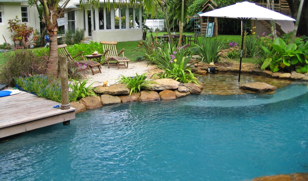 This is an example of a tropical backyard custom-shaped pool in Miami.