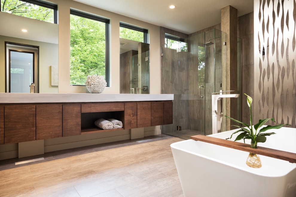 Photo of a small modern master bathroom in Minneapolis with flat-panel cabinets, medium wood cabinets, a freestanding tub, a curbless shower, beige tile, stone tile, beige walls, ceramic floors, an integrated sink and concrete benchtops.