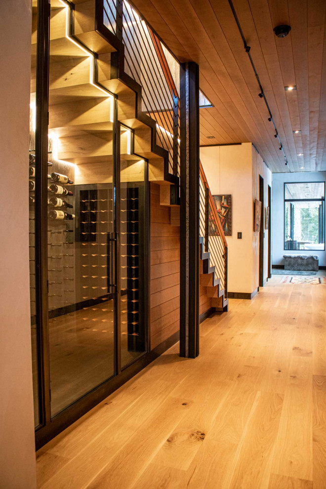 This is an example of a small arts and crafts wine cellar in Other with painted wood floors and storage racks.