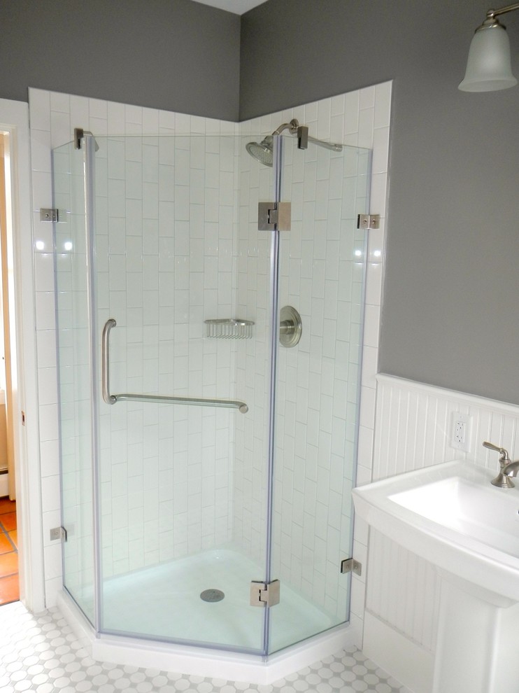 Photo of a mid-sized beach style 3/4 bathroom in Portland Maine with a pedestal sink, a corner shower, a two-piece toilet, white tile, ceramic tile, grey walls and ceramic floors.