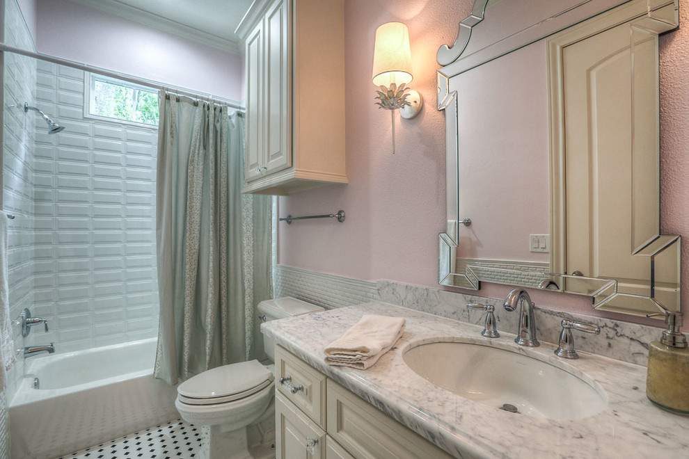 Mid-sized traditional 3/4 bathroom in Houston with raised-panel cabinets, white tile, marble floors, an undermount sink, marble benchtops, white cabinets, an alcove tub, a shower/bathtub combo, a two-piece toilet, subway tile and pink walls.
