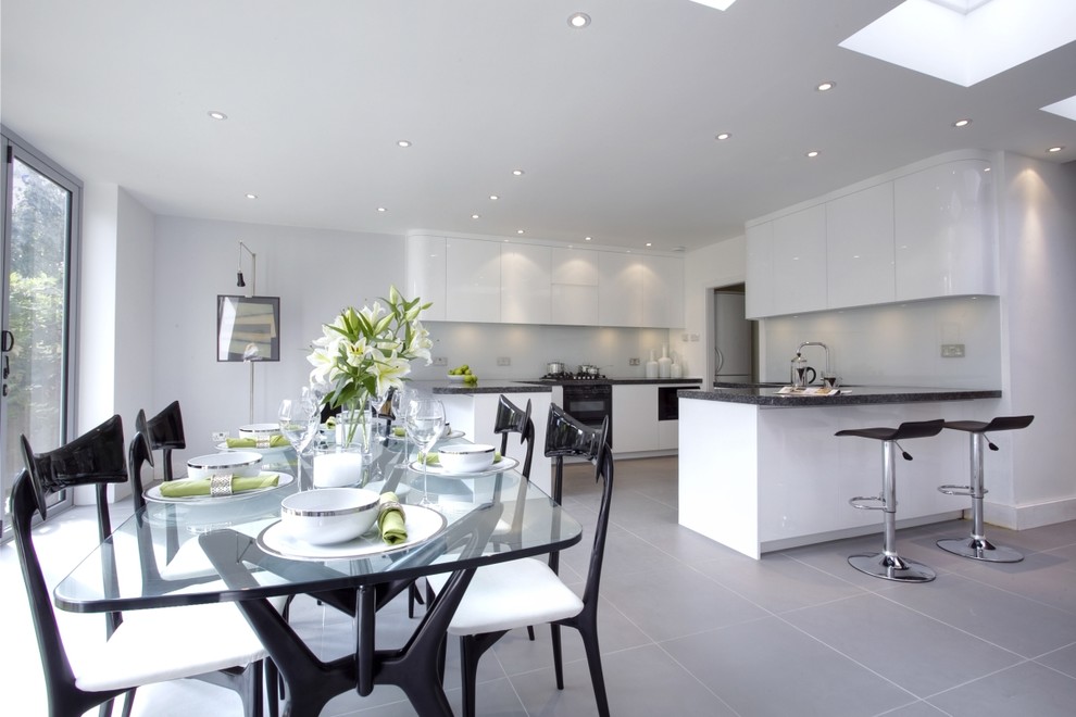 Large contemporary kitchen/dining combo in London with white walls, ceramic floors and no fireplace.