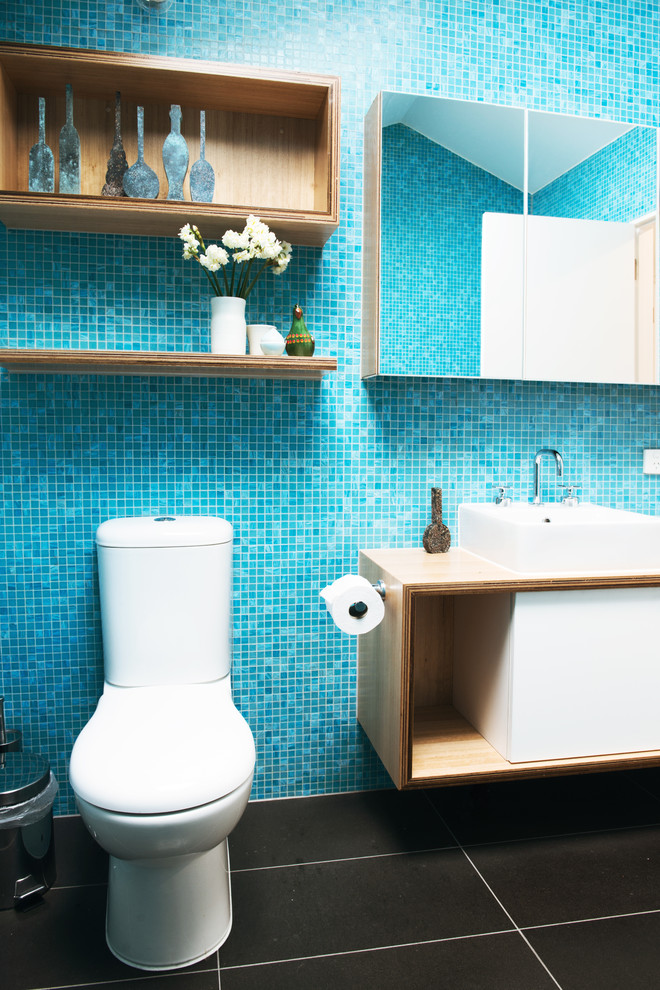 Photo of a large contemporary master bathroom in Melbourne with a console sink, flat-panel cabinets, white cabinets, wood benchtops, a one-piece toilet, blue tile, ceramic tile, blue walls and ceramic floors.
