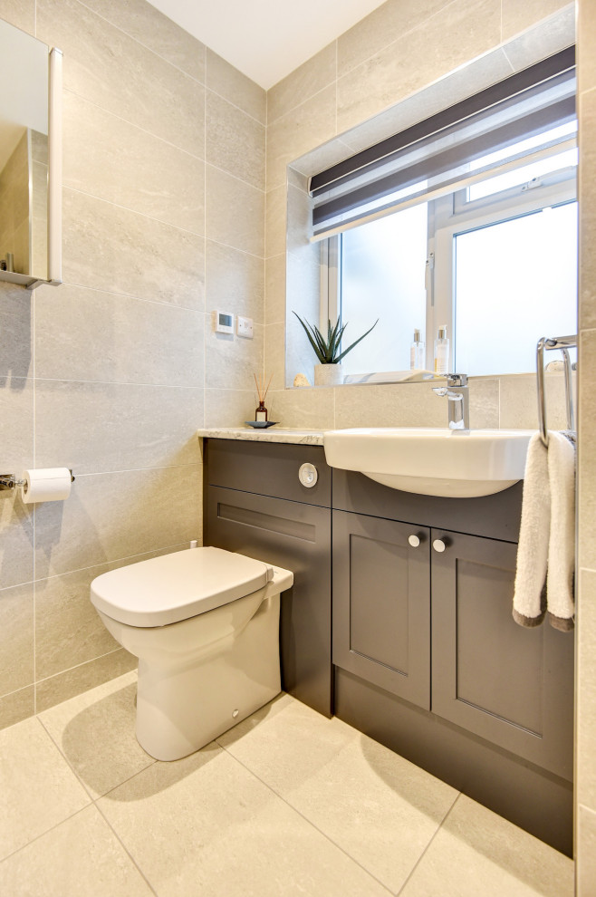 This is an example of a small modern grey and white shower room bathroom in Sussex with shaker cabinets, grey cabinets, a walk-in shower, a two-piece toilet, grey tiles, ceramic tiles, grey walls, ceramic flooring, a built-in sink, laminate worktops, grey floors, white worktops, feature lighting, a single sink and a built in vanity unit.