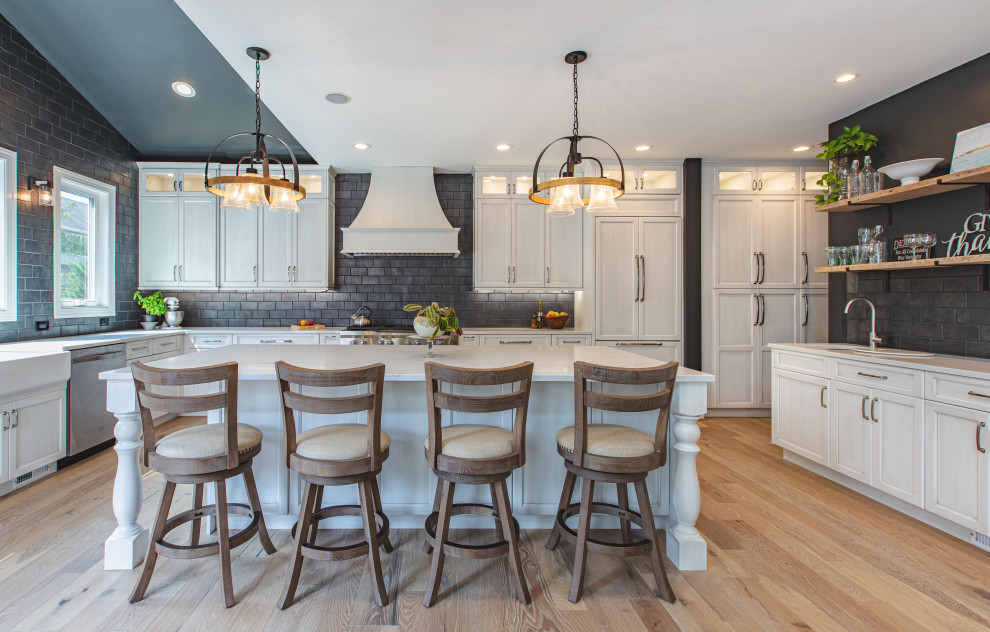 Large traditional u-shaped separate kitchen in DC Metro with recessed-panel cabinets, light wood cabinets, marble benchtops, black splashback, subway tile splashback, panelled appliances, light hardwood floors, with island, beige floor and white benchtop.