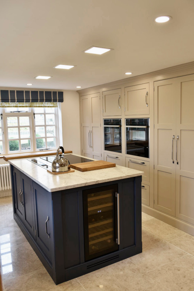 Photo of a mid-sized traditional u-shaped separate kitchen in Surrey with beaded inset cabinets, beige cabinets, quartzite benchtops, with island and white benchtop.