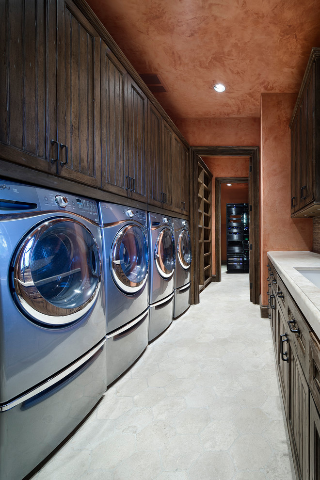 Inspiration for an expansive mediterranean galley dedicated laundry room in Houston with an undermount sink, recessed-panel cabinets, dark wood cabinets, a side-by-side washer and dryer, beige floor and beige benchtop.