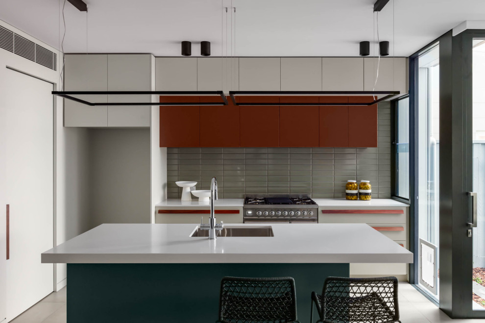 Photo of a large contemporary l-shaped eat-in kitchen in Sydney with an undermount sink, flat-panel cabinets, red cabinets, white splashback, ceramic splashback, stainless steel appliances, porcelain floors, with island and beige floor.