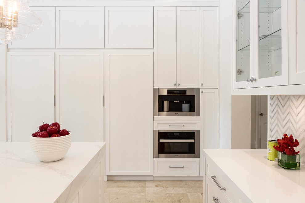 Inspiration for a mid-sized contemporary l-shaped kitchen pantry in Miami with a farmhouse sink, shaker cabinets, white cabinets, quartzite benchtops, grey splashback, marble splashback, stainless steel appliances, marble floors, with island, beige floor and white benchtop.