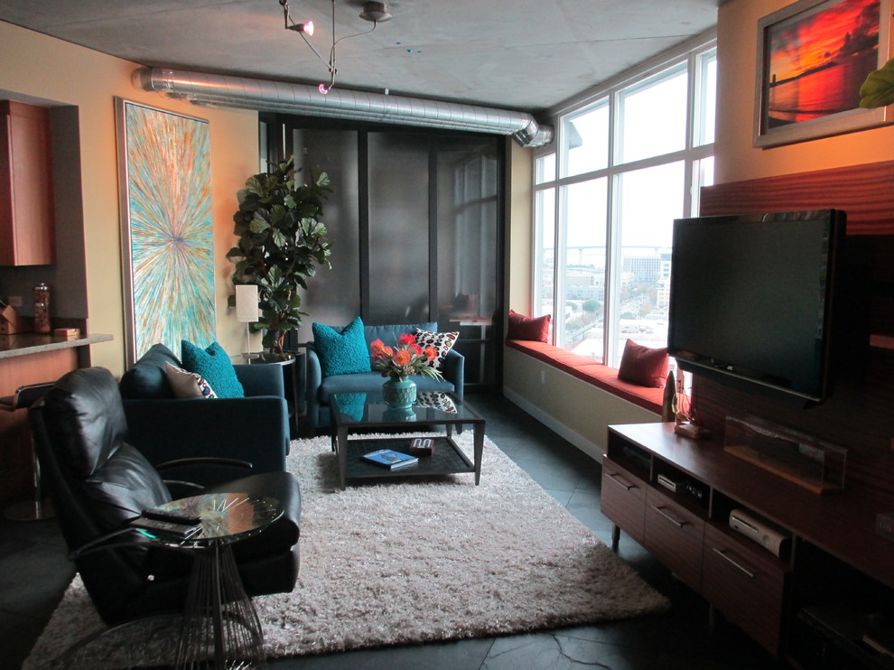 Photo of a small contemporary loft-style living room in San Diego with slate floors and a wall-mounted tv.