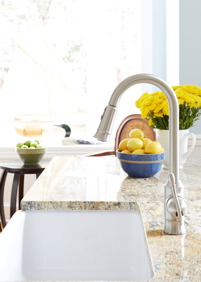 Inspiration for a transitional medium tone wood floor eat-in kitchen remodel in DC Metro with a farmhouse sink, recessed-panel cabinets, white cabinets, granite countertops, white backsplash, subway tile backsplash, stainless steel appliances and an island