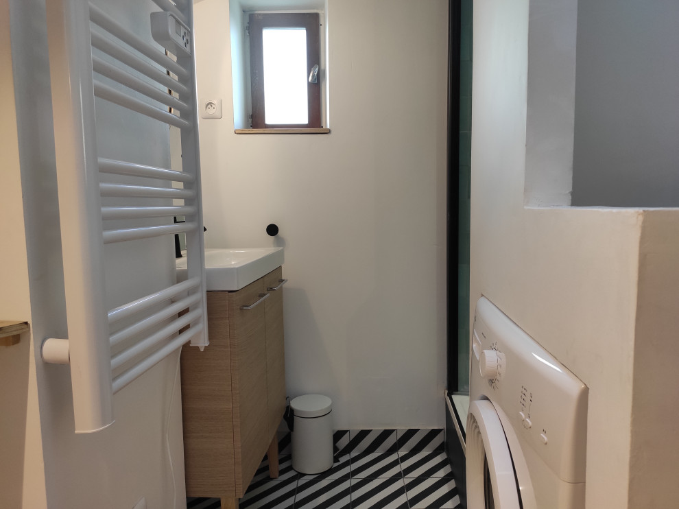 This is an example of a small eclectic 3/4 bathroom in Lyon with beaded inset cabinets, light wood cabinets, a two-piece toilet, blue tile, terra-cotta tile, white walls, ceramic floors, a drop-in sink, solid surface benchtops, black floor, a hinged shower door, white benchtops, a niche, a single vanity, a freestanding vanity and exposed beam.