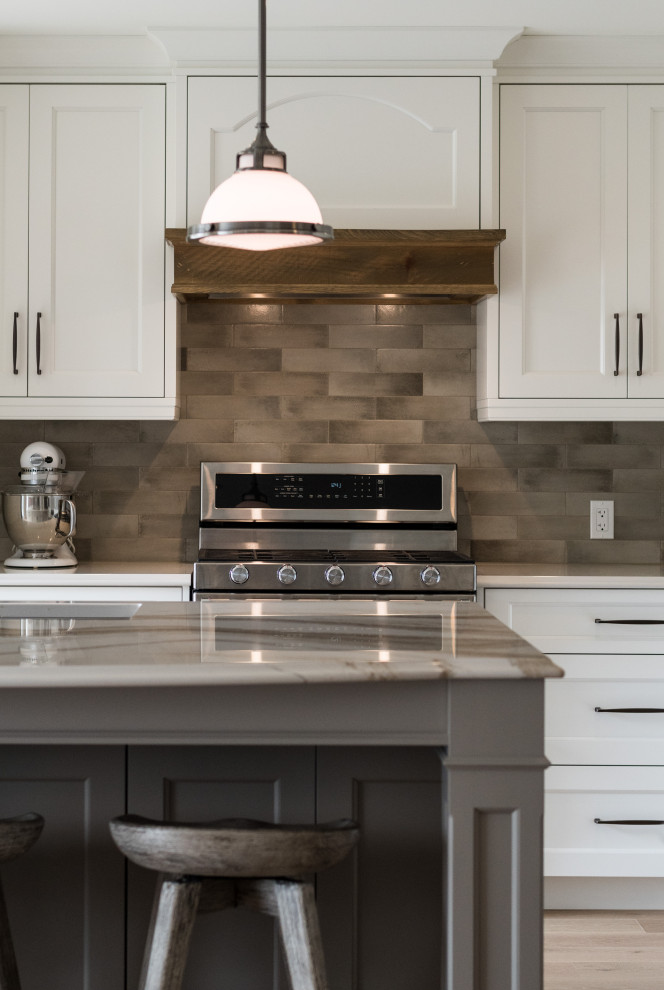 Inspiration for a transitional l-shaped eat-in kitchen in Toronto with raised-panel cabinets, white cabinets, quartz benchtops, grey splashback, stainless steel appliances, with island, multi-coloured benchtop, a double-bowl sink and brown floor.