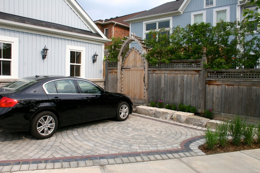 Photo of a mid-sized transitional partial sun front yard stone driveway in Toronto for summer.