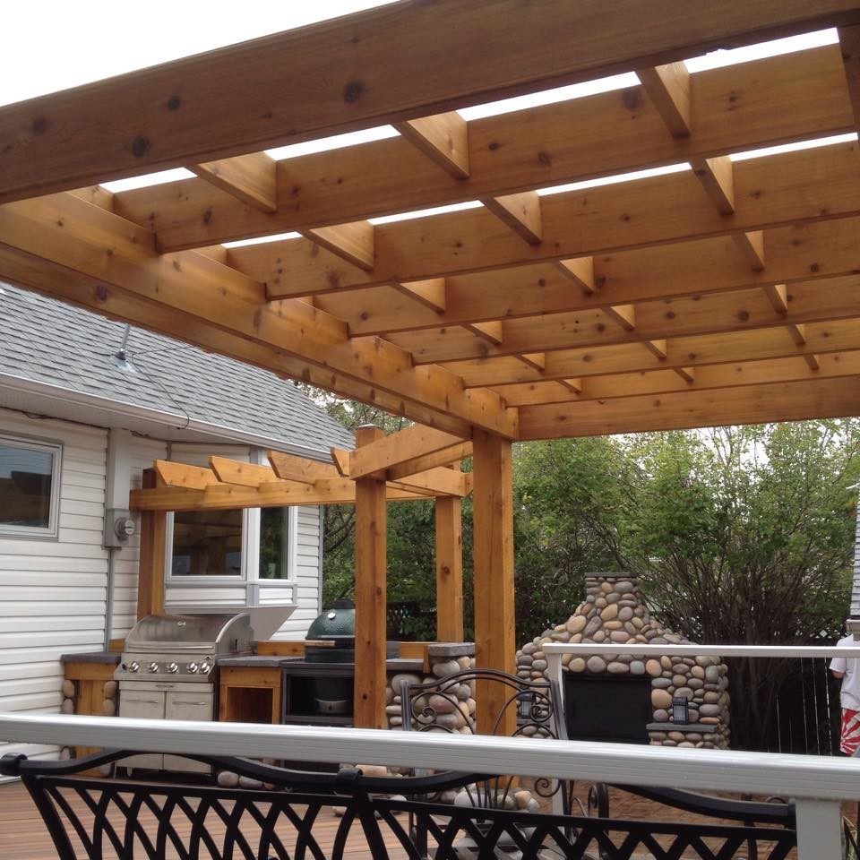 Example of a large eclectic backyard outdoor kitchen deck design in Calgary with a pergola