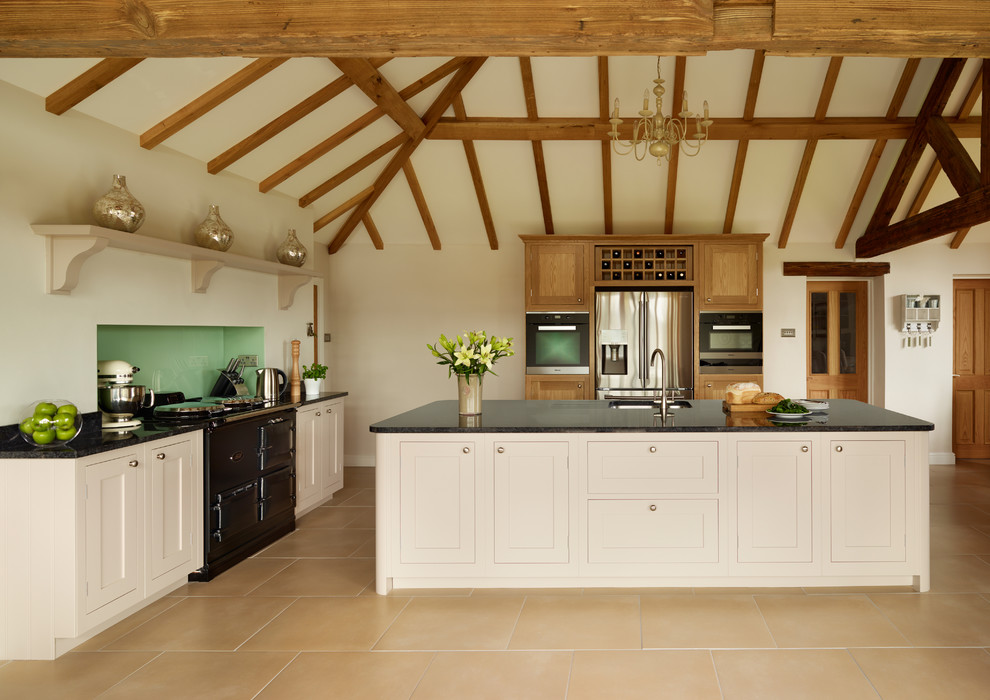 Photo of a country kitchen in London with black appliances and with island.
