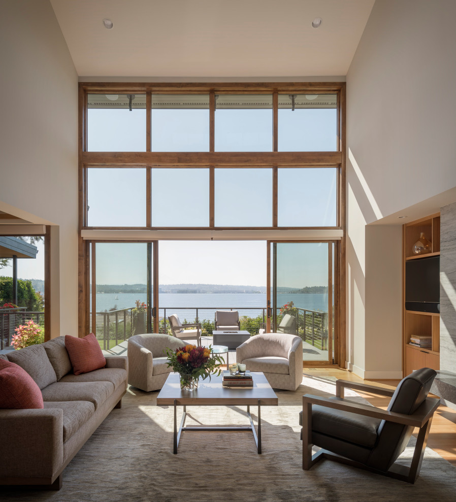 Large contemporary open concept living room in Seattle with light hardwood floors, a standard fireplace, a stone fireplace surround and a built-in media wall.