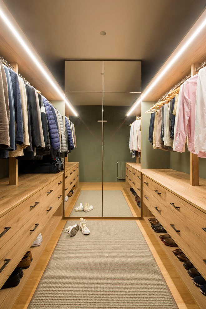 This is an example of a scandinavian gender-neutral dressing room in Barcelona with medium wood cabinets, medium hardwood floors, flat-panel cabinets and brown floor.