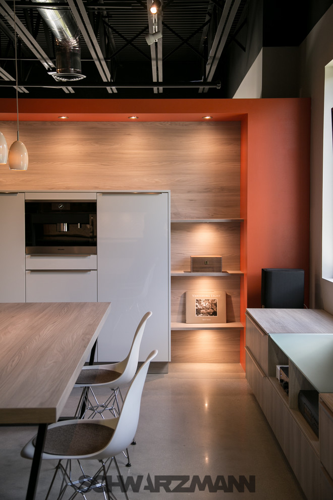 Design ideas for a mid-sized modern l-shaped open plan kitchen in Miami with an undermount sink, flat-panel cabinets, yellow cabinets, quartz benchtops, orange splashback, stone slab splashback, stainless steel appliances, concrete floors and a peninsula.